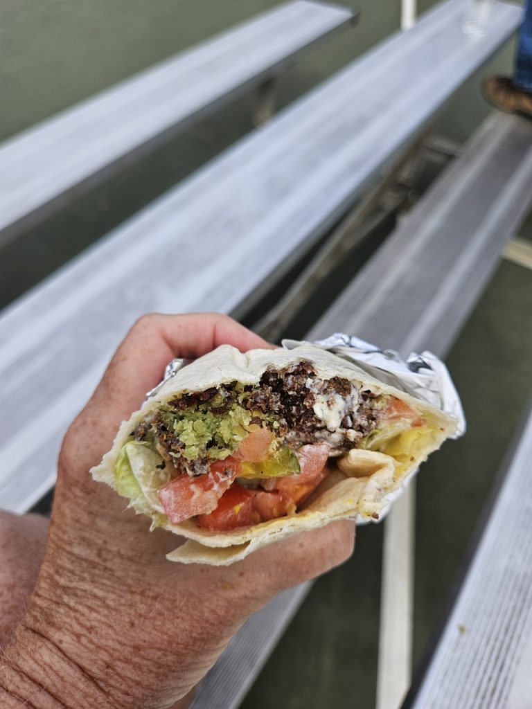 Falafel sandwich open end, with tomato and lettuce visible